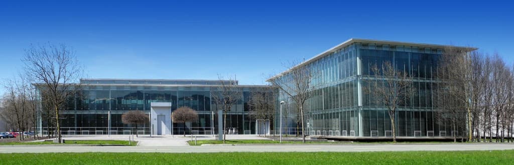 Gläsernes Bürogebäude des GlessHub im Millennium Park unter blauem Himmel