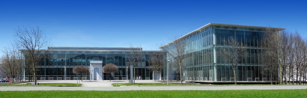 GlessHub glass office building at Millennium Park beneath a blue sky