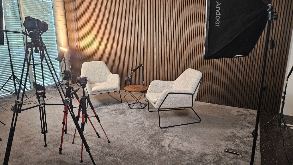 GlessHub Studio with interview chairs, cameras and a wooden slat backdrop