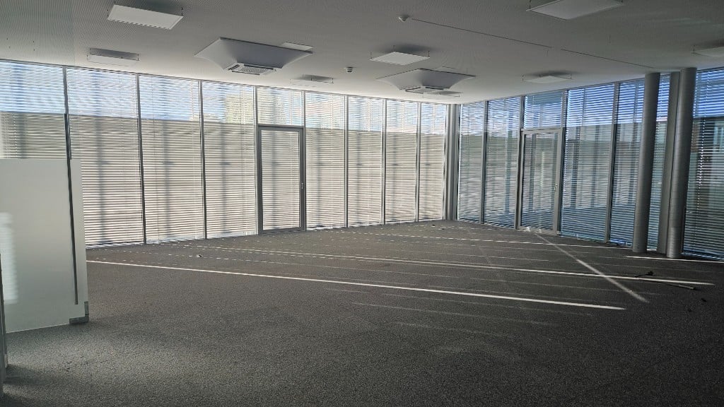 Große, helle Bürofläche mit Glasfassade, Jalousien und Teppichboden im GlessHub